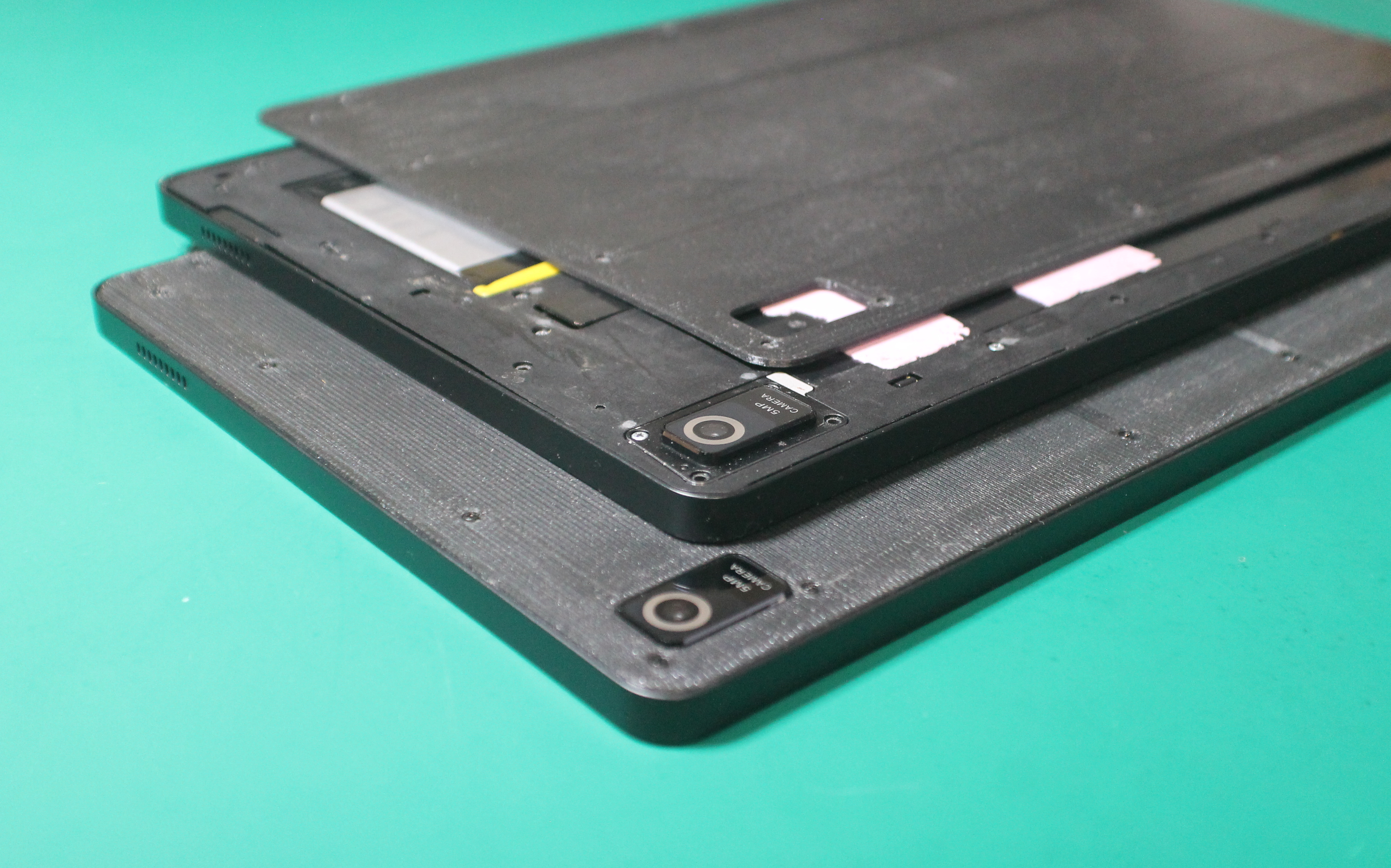 Photo of a Librem 11 with 3D-printed modular back, a Librem 11 with back removed, and a second modular back